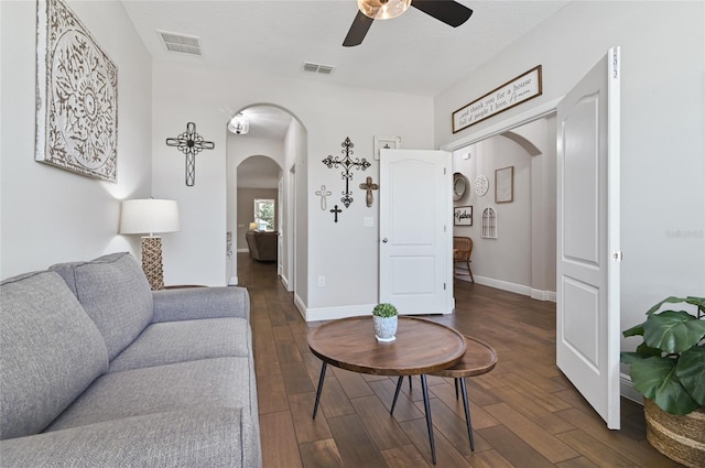 living room with ceiling fan, dark hardwood / wood-style floors, and a textured ceiling