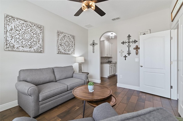 living room with ceiling fan and dark hardwood / wood-style flooring