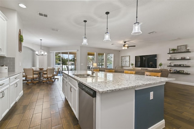 kitchen with stainless steel dishwasher, sink, a center island with sink, and white cabinets