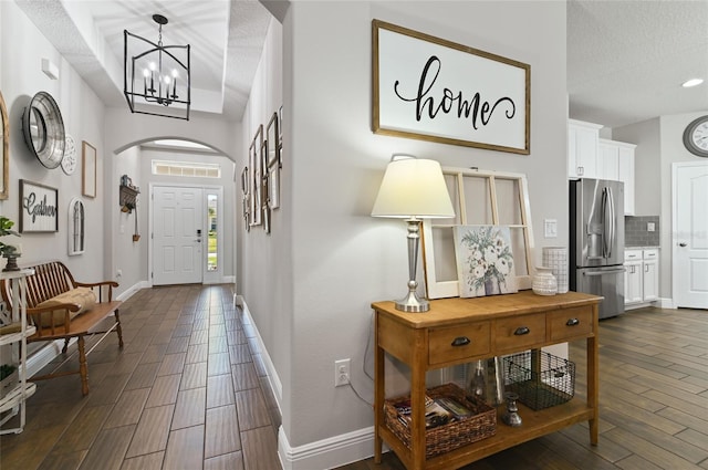 entrance foyer with dark hardwood / wood-style flooring, a chandelier, and a textured ceiling