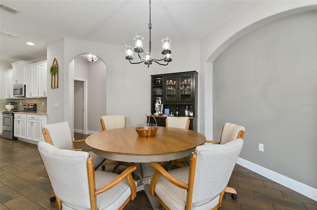 dining area with a notable chandelier and dark hardwood / wood-style flooring