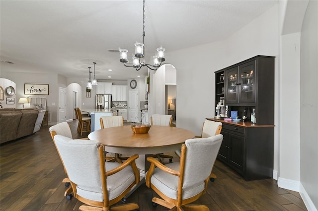 dining space featuring a notable chandelier and dark wood-type flooring