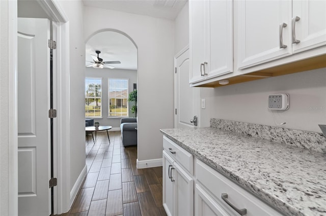 kitchen featuring white cabinetry, light stone countertops, and ceiling fan