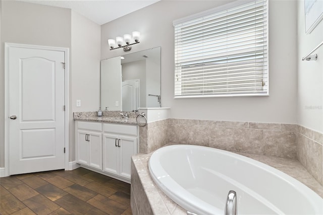 bathroom featuring vanity and tiled tub