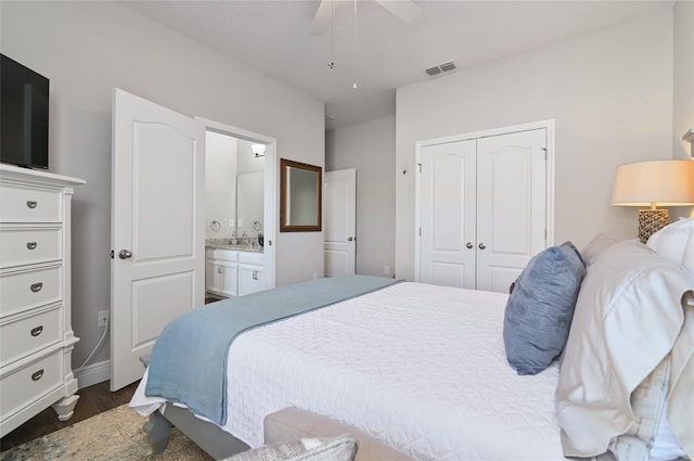 bedroom featuring ensuite bath, dark wood-type flooring, a closet, and ceiling fan