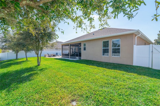 rear view of house featuring a yard and a sunroom