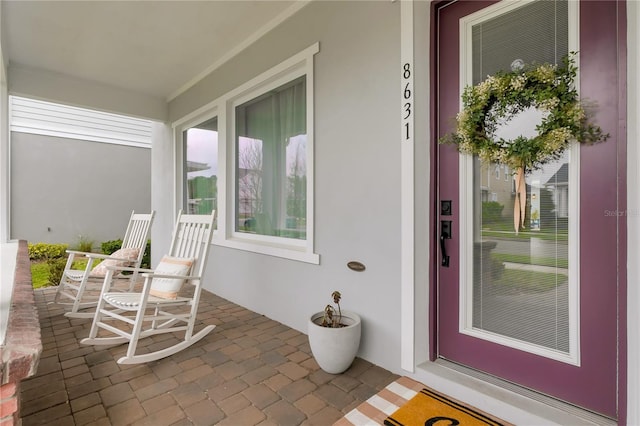 property entrance featuring stucco siding and covered porch