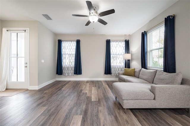 living room with dark wood-type flooring and ceiling fan