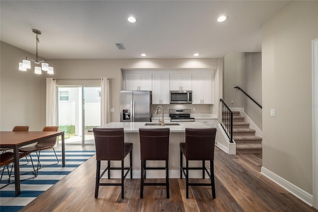 kitchen featuring white cabinetry, appliances with stainless steel finishes, sink, and pendant lighting