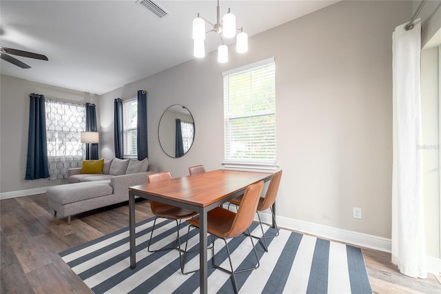 dining room featuring hardwood / wood-style flooring, plenty of natural light, and ceiling fan with notable chandelier