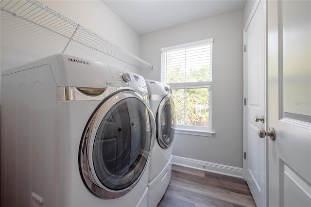 washroom with washing machine and dryer and dark hardwood / wood-style floors