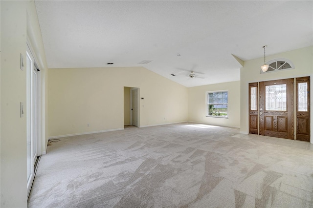 foyer entrance with vaulted ceiling, light colored carpet, ceiling fan, and a textured ceiling