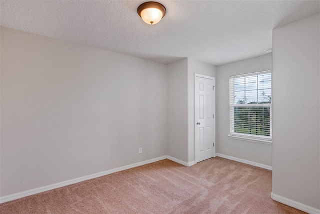 carpeted spare room featuring a textured ceiling