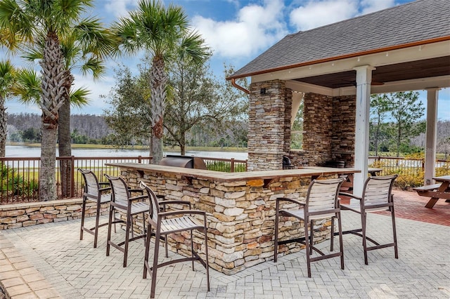 view of patio / terrace featuring a water view and an outdoor bar