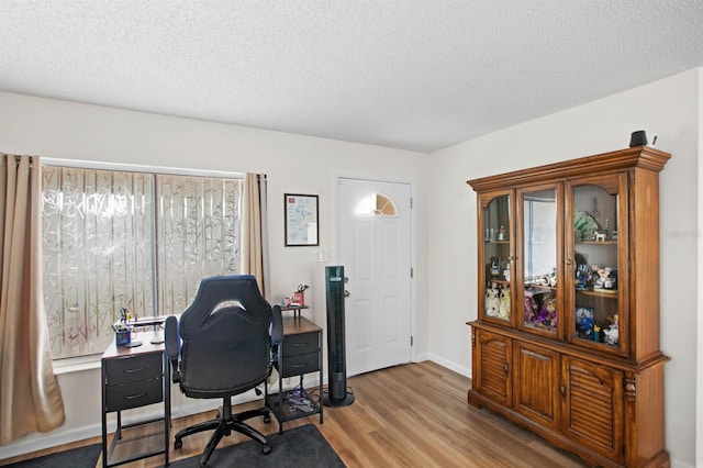 home office featuring a textured ceiling and light wood-type flooring