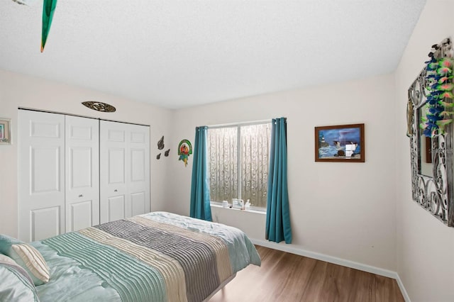 bedroom with hardwood / wood-style floors, a closet, and a textured ceiling