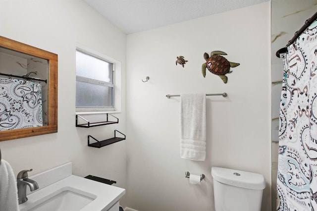 bathroom with a shower with curtain, vanity, toilet, and a textured ceiling