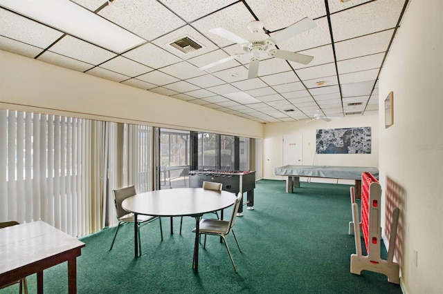 recreation room featuring carpet floors, ceiling fan, and a paneled ceiling