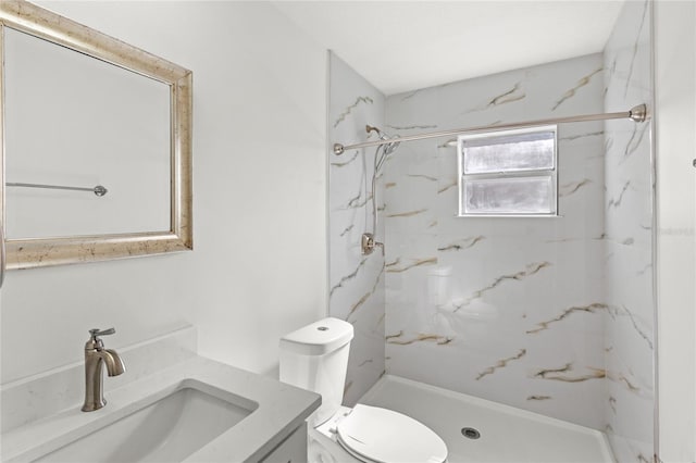 bathroom featuring a marble finish shower, vanity, and toilet