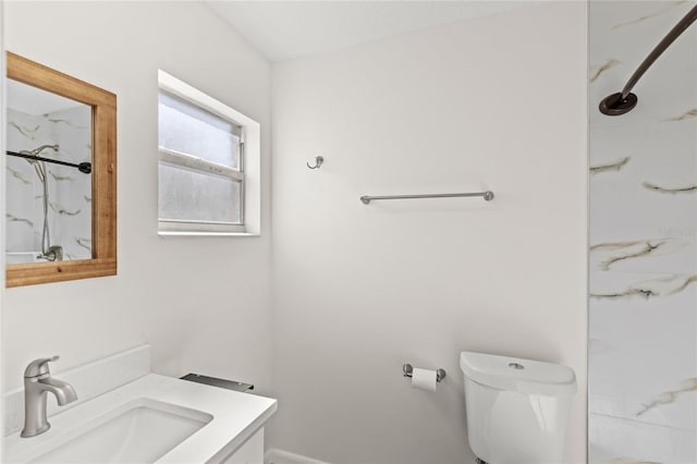 bathroom featuring a marble finish shower, vanity, and toilet