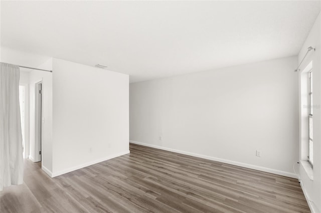 empty room with baseboards and wood finished floors