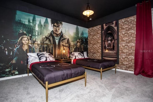 carpeted home theater room featuring brick wall