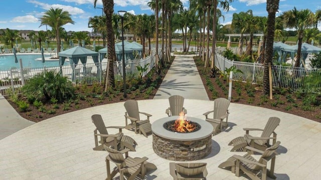 view of home's community featuring a pool, a patio area, and an outdoor fire pit