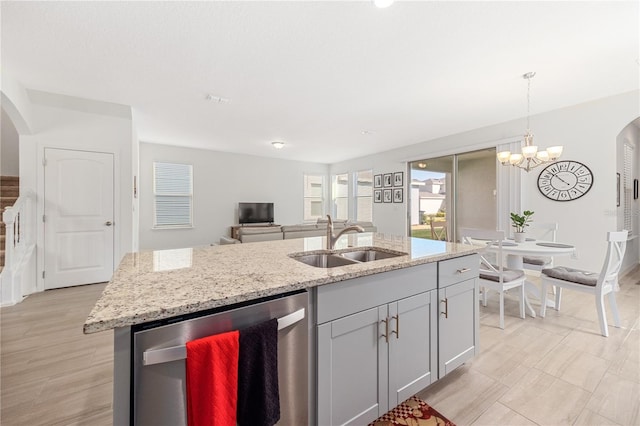 kitchen featuring sink, gray cabinets, a kitchen island with sink, hanging light fixtures, and stainless steel dishwasher