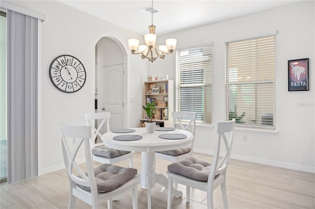 dining area featuring a notable chandelier and light hardwood / wood-style flooring