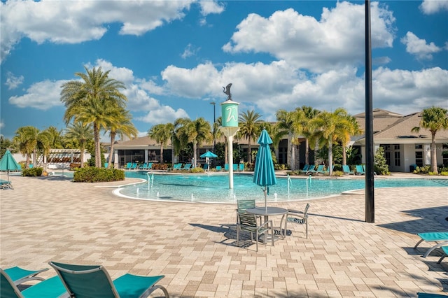 view of swimming pool featuring pool water feature and a patio