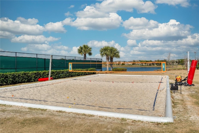 view of home's community with volleyball court and a water view