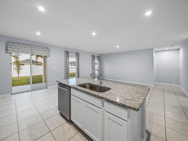 kitchen featuring dishwasher, sink, white cabinets, a kitchen island with sink, and light stone counters