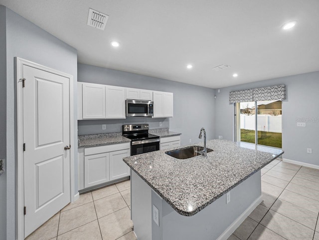 kitchen featuring white cabinetry, sink, stainless steel appliances, and a center island with sink