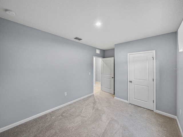 unfurnished bedroom featuring light carpet