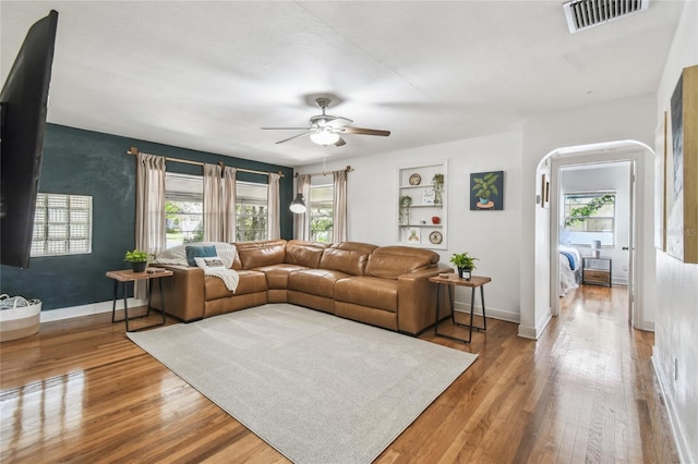 living area featuring hardwood / wood-style flooring, visible vents, and a healthy amount of sunlight