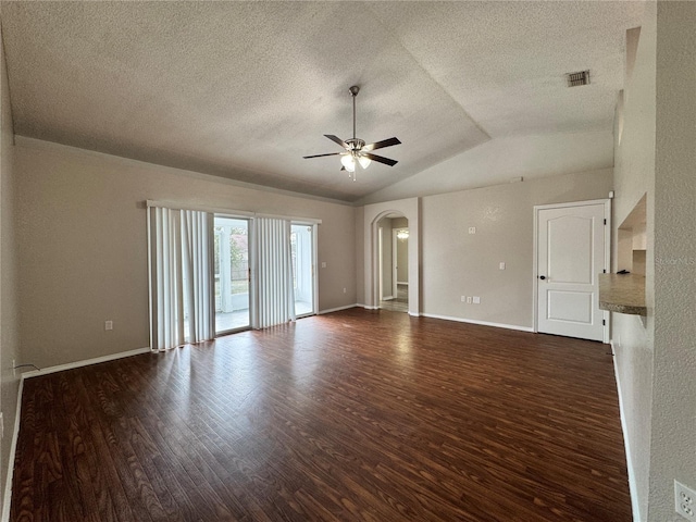 empty room with a textured ceiling, dark wood-type flooring, ceiling fan, and vaulted ceiling