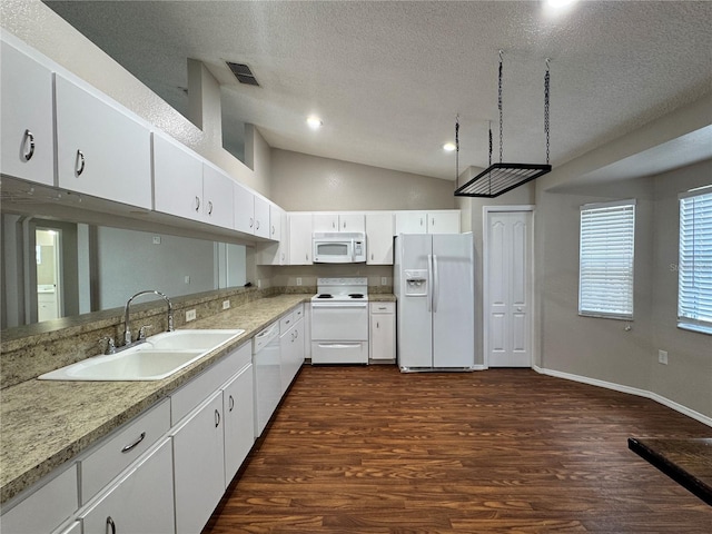 kitchen featuring vaulted ceiling, sink, white cabinets, dark wood-type flooring, and white appliances