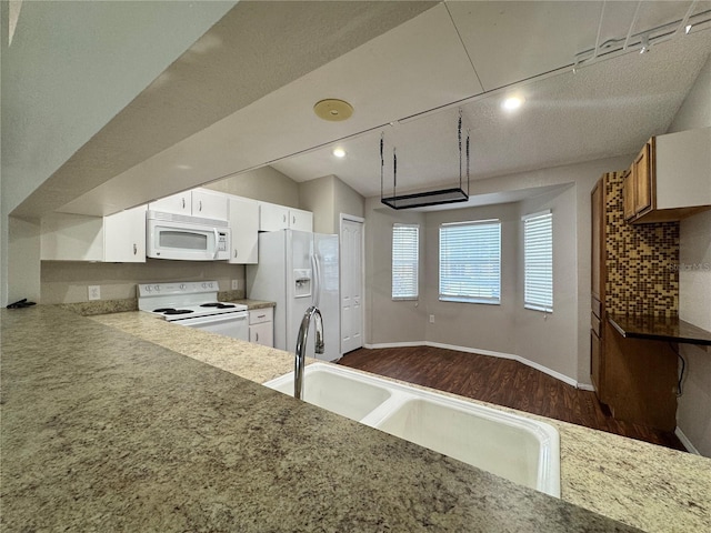 kitchen featuring sink, white cabinetry, track lighting, dark hardwood / wood-style flooring, and white appliances