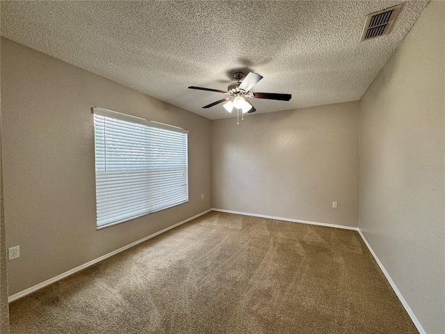 carpeted empty room with ceiling fan and a textured ceiling