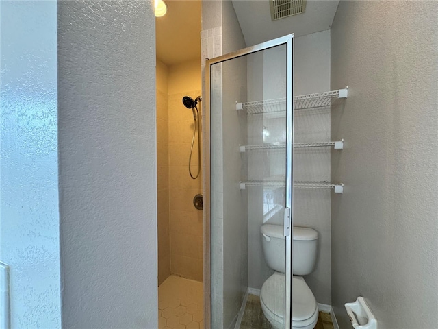 bathroom featuring walk in shower and toilet