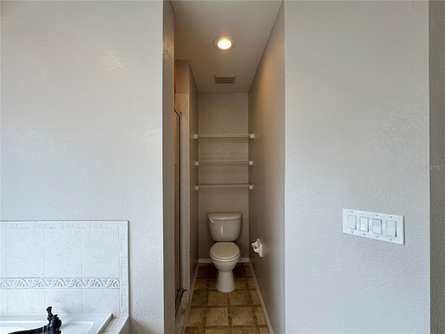 bathroom featuring tile patterned floors, toilet, and plus walk in shower