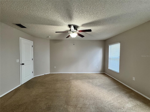 spare room featuring ceiling fan, carpet floors, and a textured ceiling