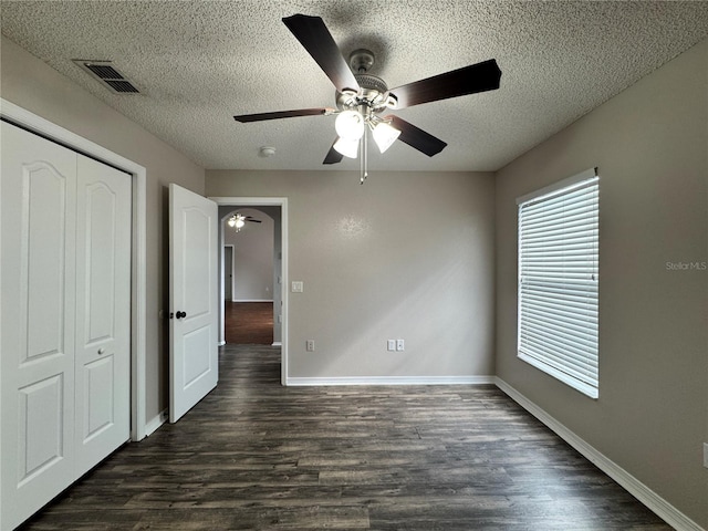 unfurnished bedroom featuring dark hardwood / wood-style flooring, a closet, and a textured ceiling