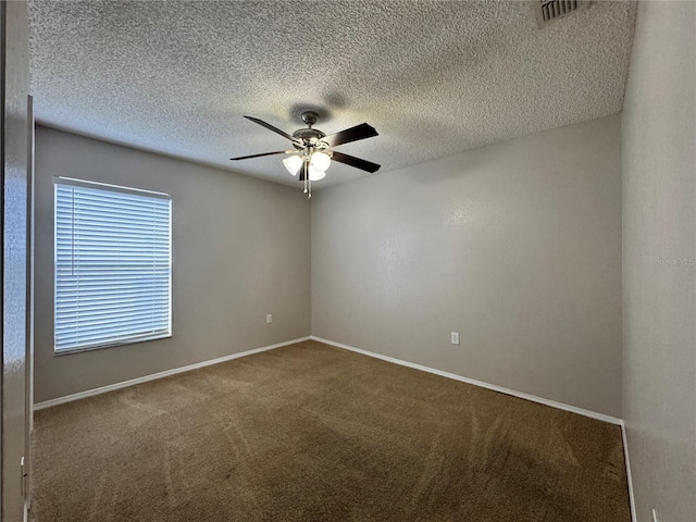 carpeted empty room with ceiling fan and a textured ceiling