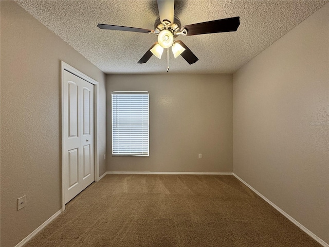 carpeted spare room featuring ceiling fan and a textured ceiling