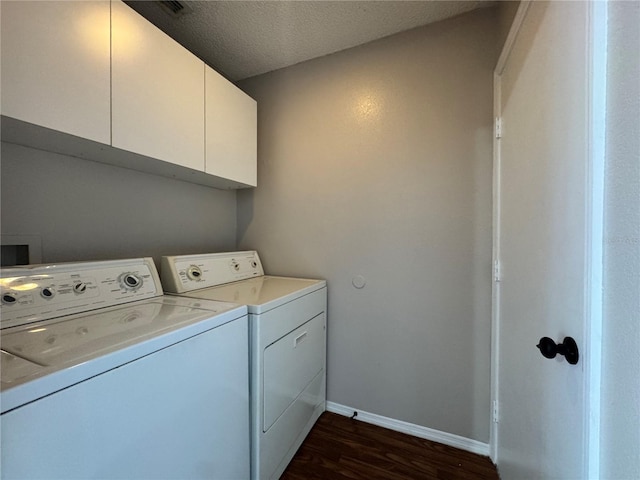 clothes washing area with separate washer and dryer, dark hardwood / wood-style flooring, cabinets, and a textured ceiling