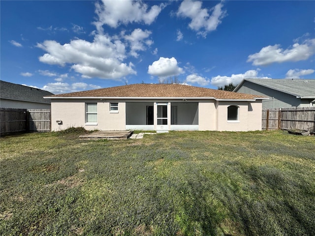 rear view of house featuring a yard