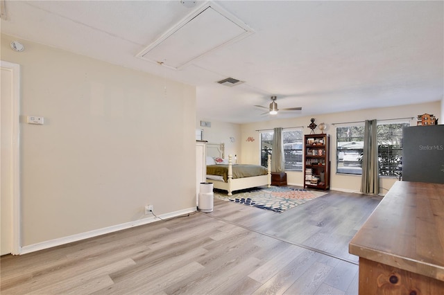 unfurnished living room with baseboards, wood finished floors, visible vents, and attic access