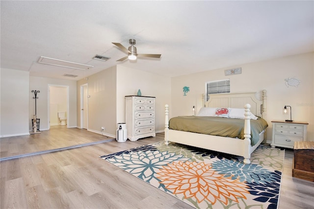 bedroom with visible vents, attic access, ceiling fan, wood finished floors, and baseboards