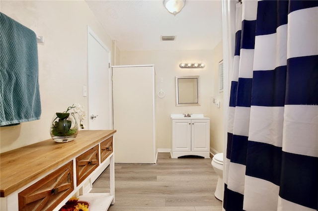 full bathroom featuring visible vents, vanity, toilet, and wood finished floors